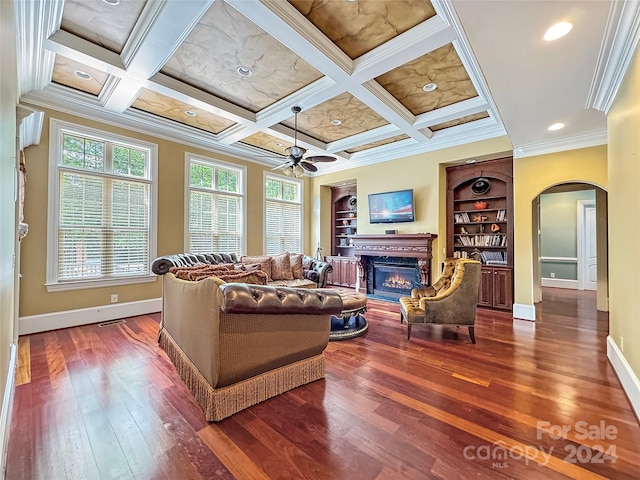 living room with ceiling fan, built in features, ornamental molding, coffered ceiling, and beamed ceiling