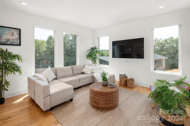 living room with recessed lighting, light wood-style flooring, and baseboards