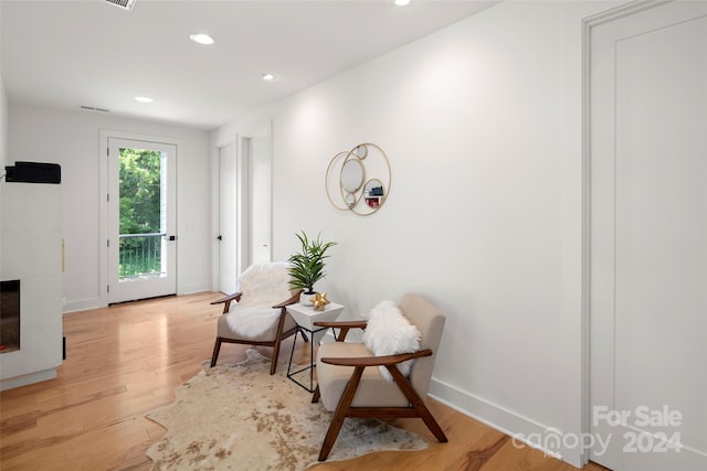 living area featuring recessed lighting, baseboards, light wood-style floors, and a fireplace