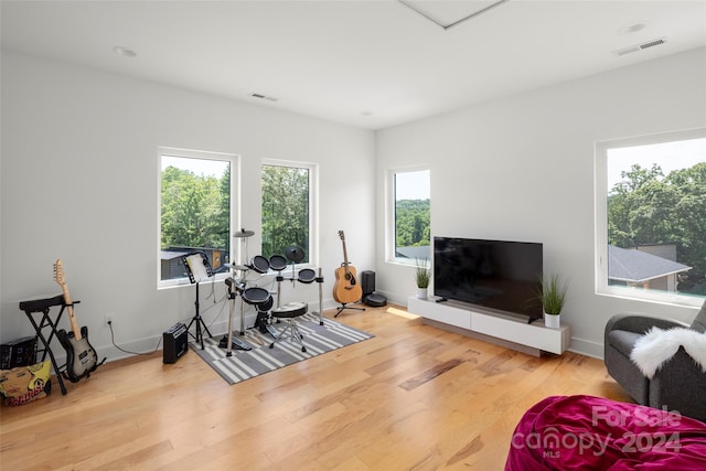exercise area featuring wood finished floors, visible vents, and baseboards
