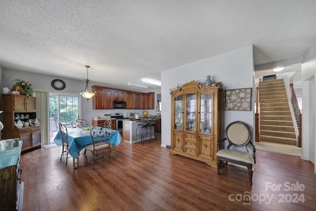 dining room featuring a textured ceiling and dark wood-type flooring