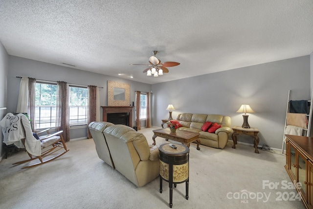 living room featuring a textured ceiling, light colored carpet, and ceiling fan