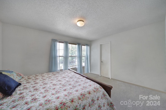 bedroom featuring a textured ceiling and carpet floors