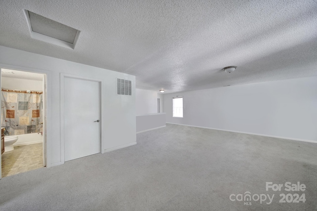 unfurnished room featuring carpet floors and a textured ceiling