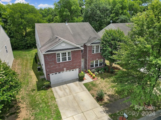 view of front of property with cooling unit, a front lawn, and a garage