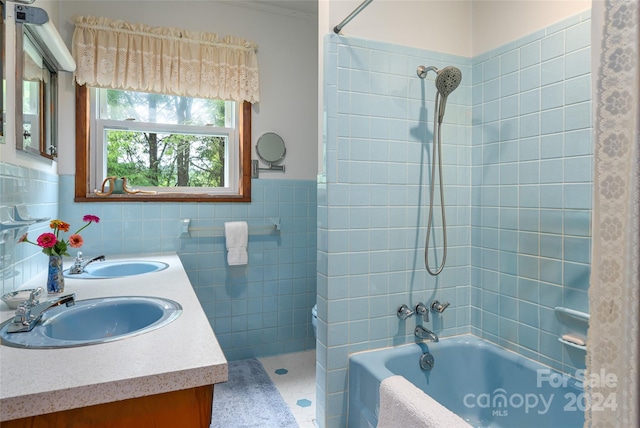 bathroom featuring tiled shower / bath, tile walls, dual bowl vanity, and tile patterned flooring