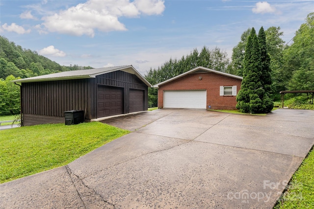 view of property exterior with a garage, a yard, and an outdoor structure