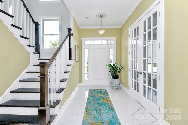 foyer entrance featuring crown molding and plenty of natural light