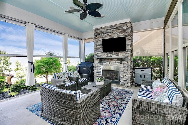 sunroom with ceiling fan and a fireplace