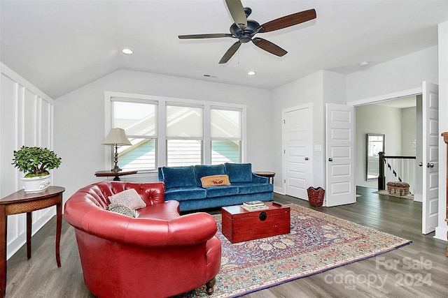 living room featuring ceiling fan, dark wood-type flooring, and vaulted ceiling