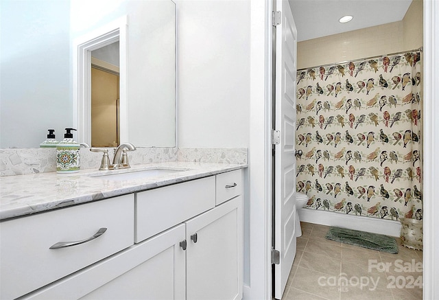 bathroom featuring tile patterned floors, toilet, vanity, and walk in shower