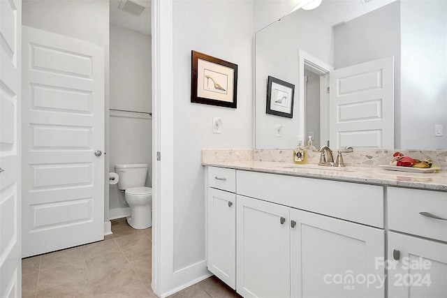 bathroom featuring vanity, toilet, and tile patterned flooring