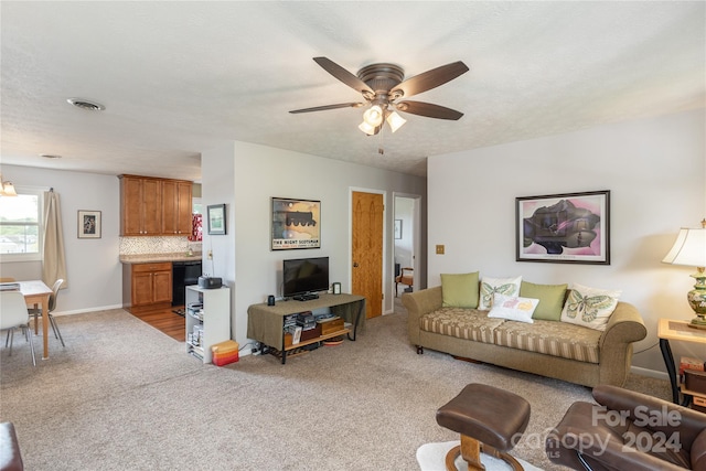 carpeted living room with ceiling fan and a textured ceiling