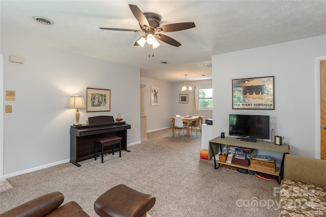 living room featuring ceiling fan with notable chandelier, a textured ceiling, and carpet flooring