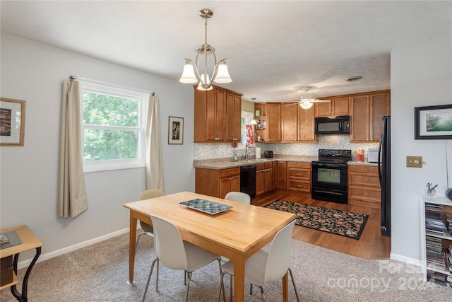 kitchen featuring decorative backsplash, pendant lighting, sink, and black appliances