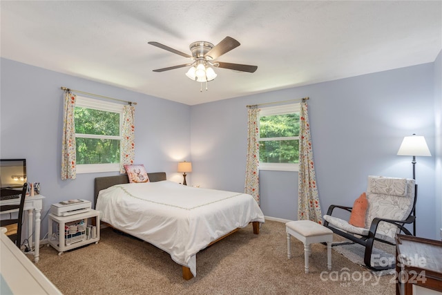 carpeted bedroom with multiple windows and ceiling fan