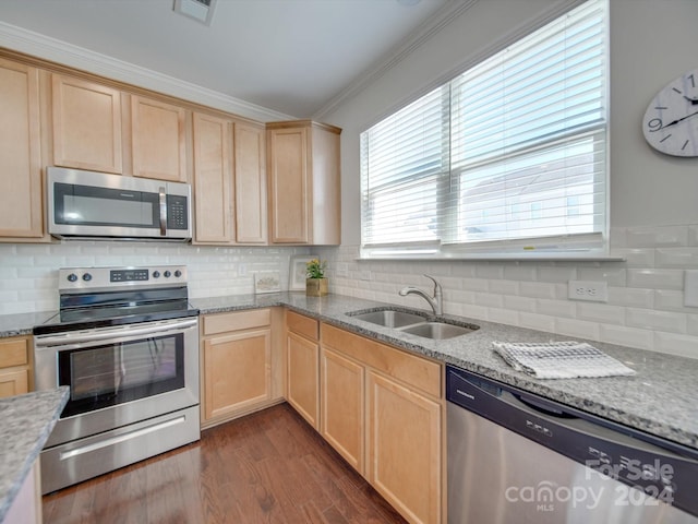 kitchen featuring light stone counters, appliances with stainless steel finishes, dark hardwood / wood-style floors, ornamental molding, and sink