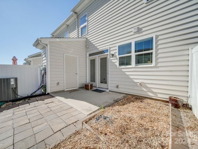 rear view of house with central AC and a patio area