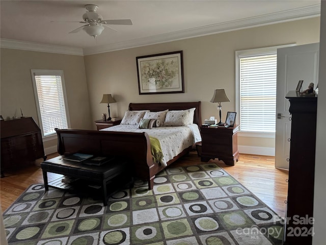 bedroom with ceiling fan, light wood-type flooring, crown molding, and multiple windows