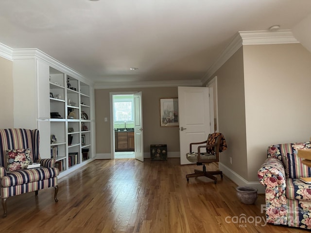 sitting room with hardwood / wood-style floors, ornamental molding, and sink