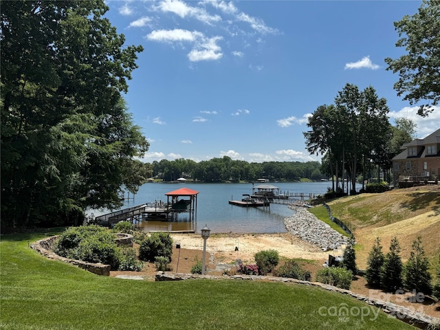 dock area with a lawn and a water view