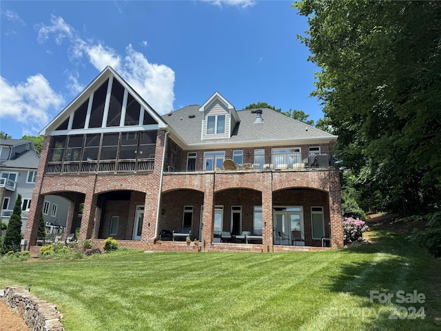 rear view of house with a lawn and a sunroom