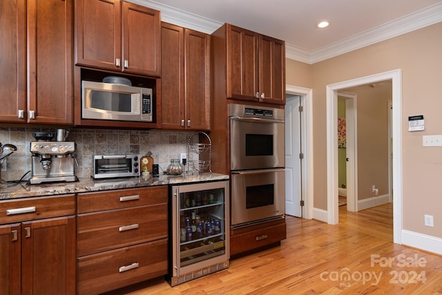 kitchen featuring dark stone counters, crown molding, appliances with stainless steel finishes, tasteful backsplash, and beverage cooler