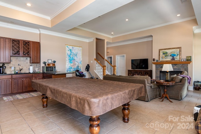 playroom featuring a tile fireplace, crown molding, light tile patterned floors, and pool table