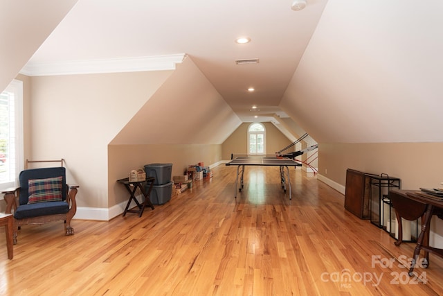 additional living space with light hardwood / wood-style floors and lofted ceiling