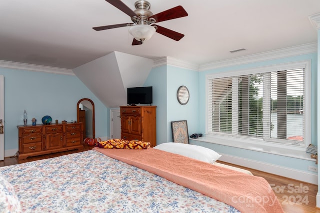 bedroom with hardwood / wood-style flooring, vaulted ceiling, ceiling fan, and ornamental molding