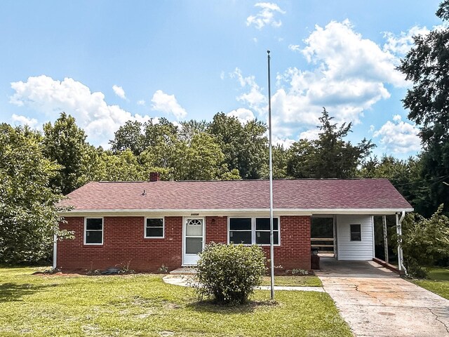 single story home with a front yard and a carport