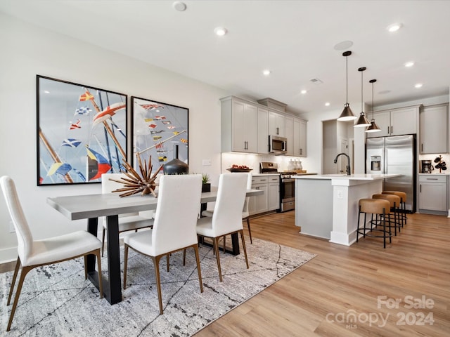 dining room with light hardwood / wood-style floors and sink