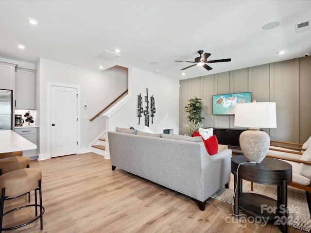 living room featuring light hardwood / wood-style floors and ceiling fan