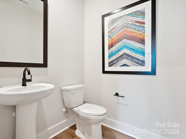 bathroom featuring toilet and wood-type flooring