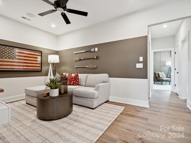 living room with ceiling fan and light hardwood / wood-style flooring