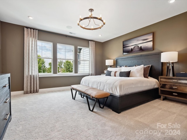 bedroom featuring light carpet and an inviting chandelier