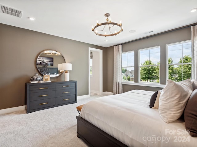 bedroom featuring light colored carpet and a notable chandelier