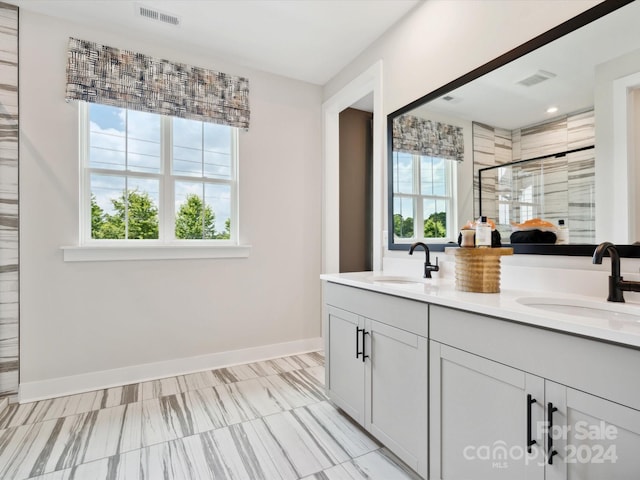 bathroom featuring a wealth of natural light, a shower with shower door, and vanity