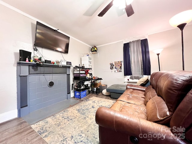 living room featuring ceiling fan, ornamental molding, and wood-type flooring