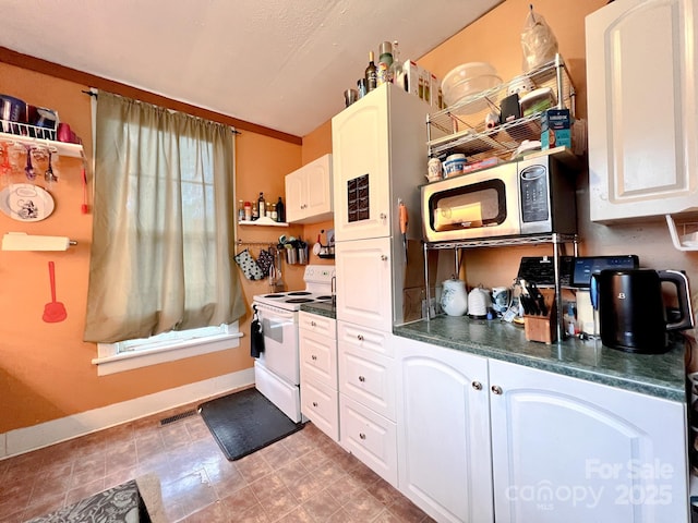 kitchen featuring white cabinetry and white electric range oven