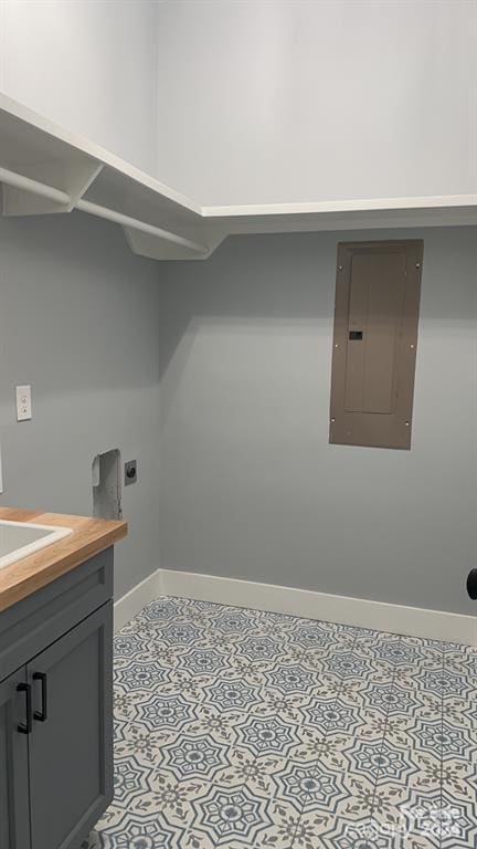 laundry area with sink, electric panel, cabinets, and hookup for an electric dryer