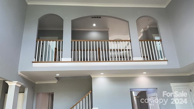 hallway featuring a high ceiling and crown molding