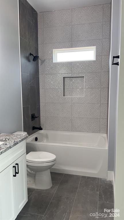 full bathroom with vanity, tile patterned floors, tiled shower / bath combo, and toilet