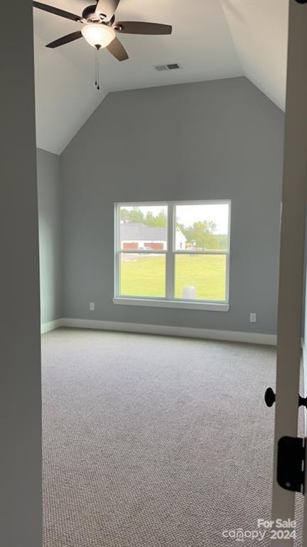 bonus room featuring lofted ceiling, light carpet, ceiling fan, and a healthy amount of sunlight