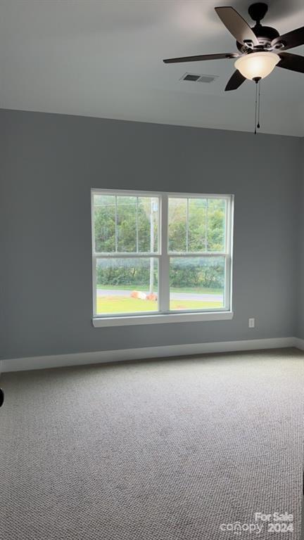 carpeted empty room featuring ceiling fan