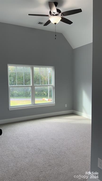 carpeted empty room with lofted ceiling and ceiling fan