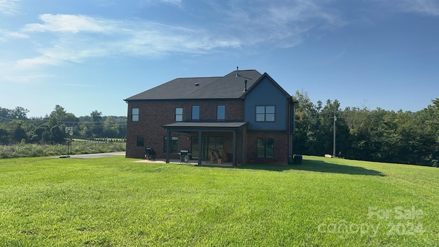 rear view of house featuring a yard and a patio area