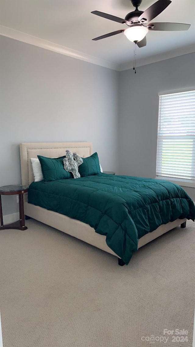 carpeted bedroom with ceiling fan and crown molding