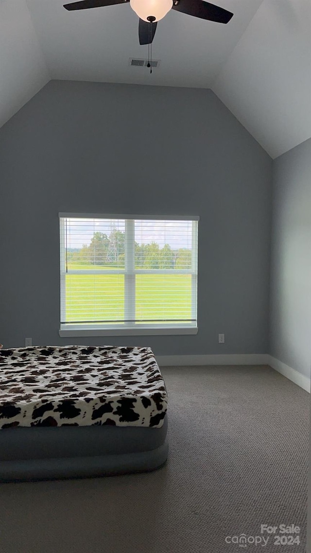 unfurnished bedroom featuring carpet flooring, ceiling fan, and vaulted ceiling