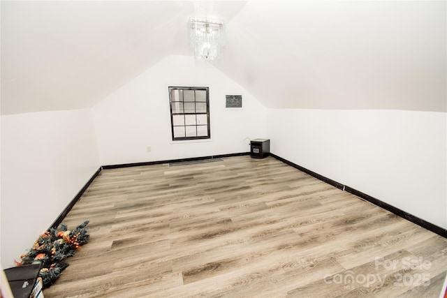 bonus room with hardwood / wood-style flooring and vaulted ceiling